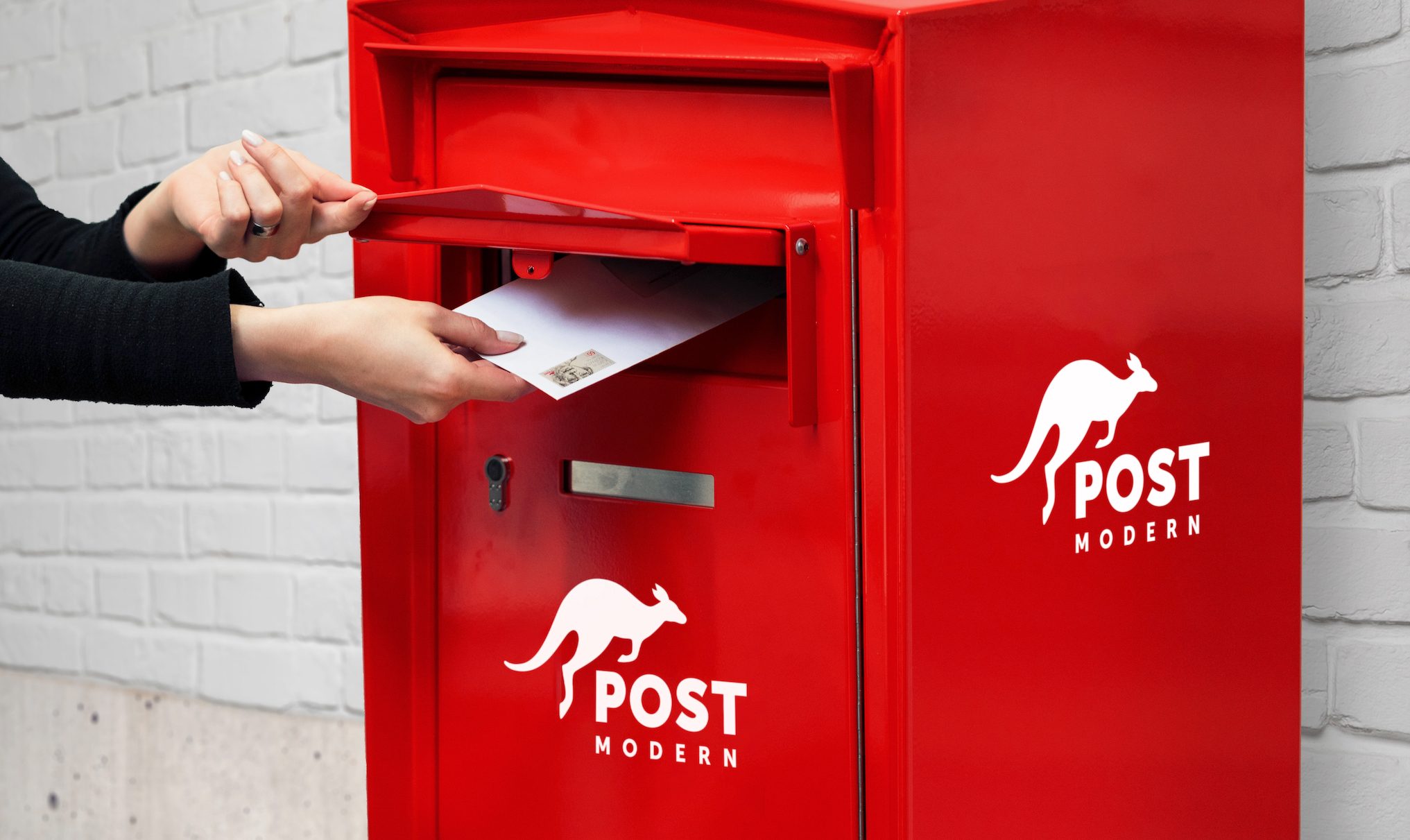 Person wirft Brief in PostModern-Briefkasten ein