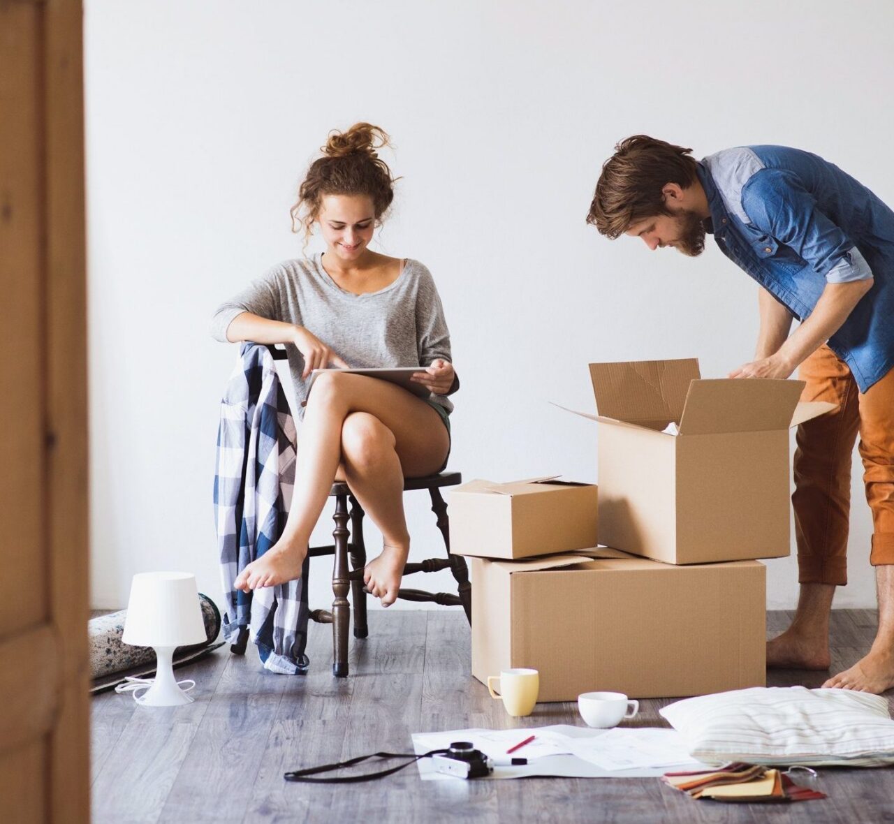 Das Bild zeigt ein frisch umgezogenes Paar beim Auspacken - Briefe werden nachgesendet.